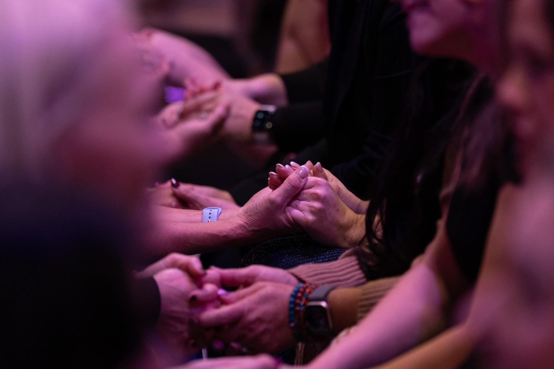 Hands clasped together in prayer at a Rise Up Queens gathering