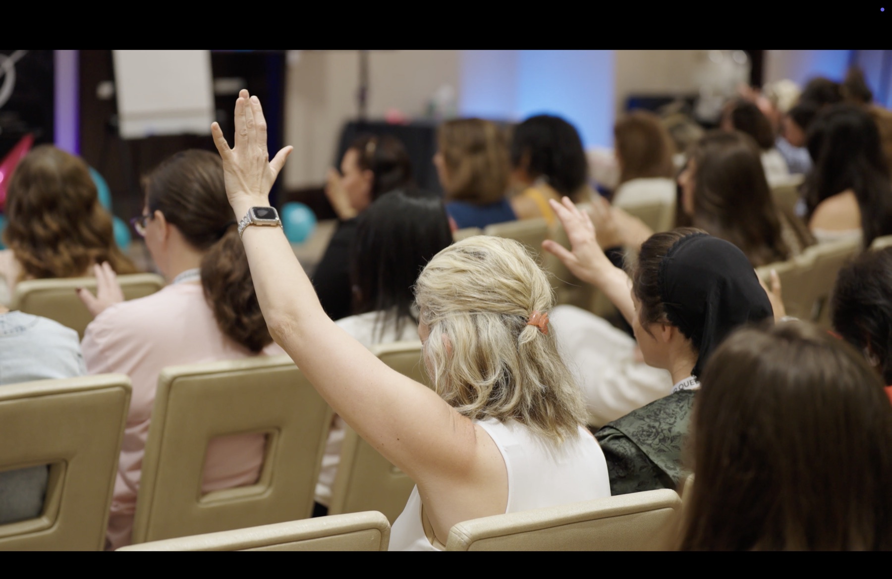 Women in worship at Rise Up Queens with hands raised