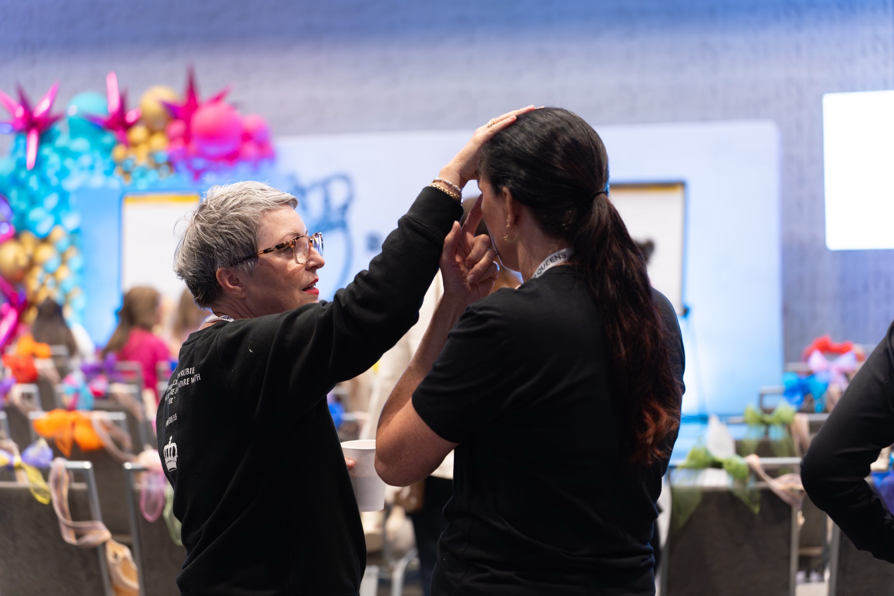 One woman praying over another with hands laid on her head