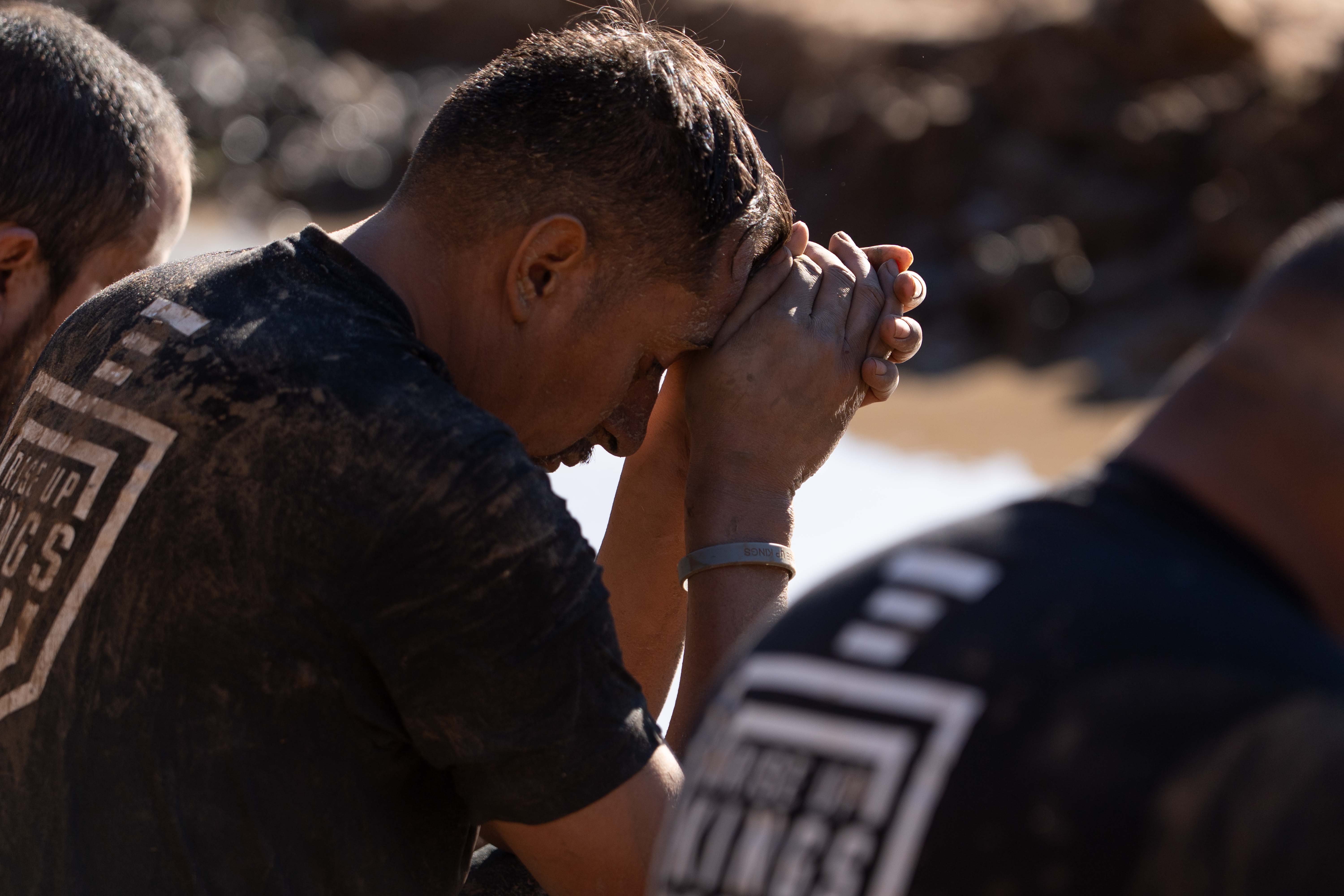 Rise Up Kings brothers bowed together in prayer outdoors